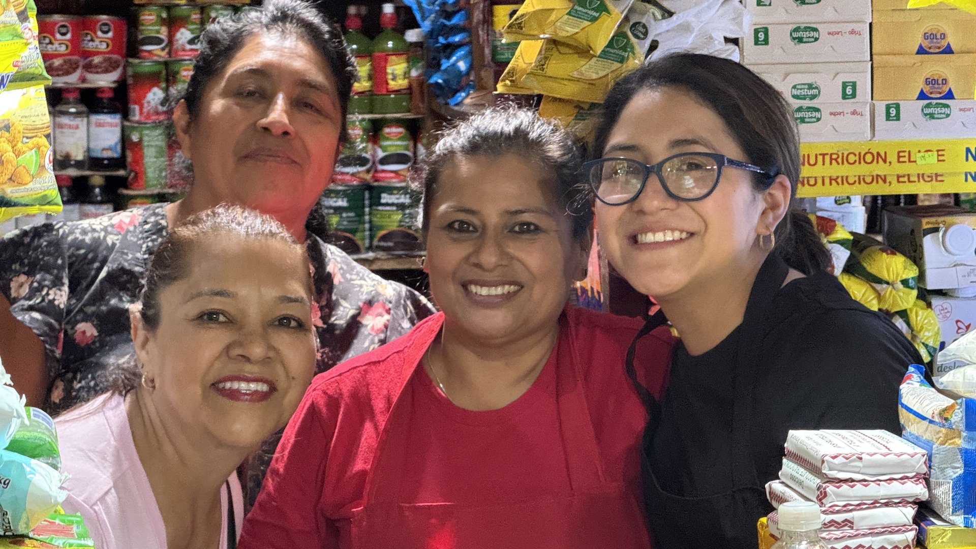 La familia de Abarrotería Hellen sonriendo juntas detrás del mostrador